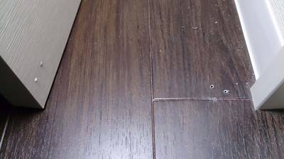 ドアストッパー撤去後の床と扉のビス穴補修前の写真