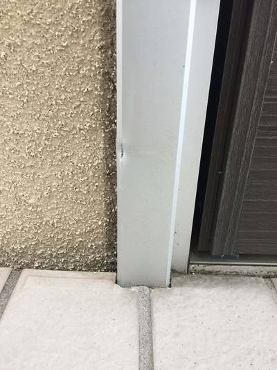 傷のあるアルミ玄関ドアの枠部分
