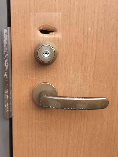 補修前の玄関ドアの穴と色剥げ