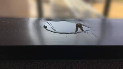 ベランダの金属製笠木に大きな凹みがあり雨水が溜まっている状態