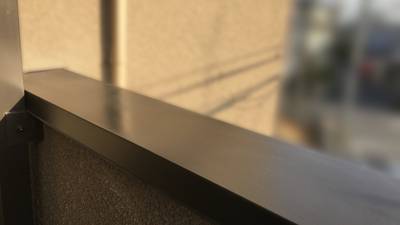 補修により凹みがなくなり綺麗に塗装されたダークブロンズ色の笠木