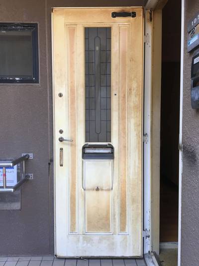 全体的にタバコのヤニが付着し、茶色く変色してしまったマンションの白い玄関ドアの内側