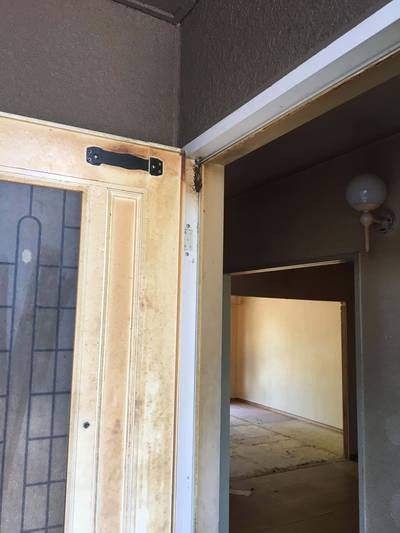 ドアの上枠付近や金具周りにこびりついた、茶色いタバコのヤニ汚れの拡大写真