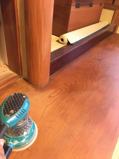 マキタ製の電動サンダーを使用し、劣化した古い塗膜を削り落として木地を出している様子