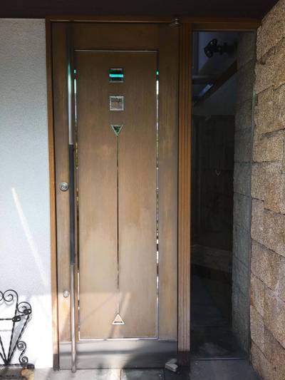 色褪せが目立つ木製玄関ドア