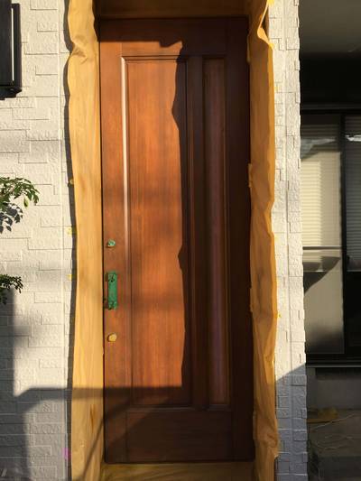 木目を美しく引き立たせるため、刷毛を使って丁寧に色を重ね、全体の色味を統一している様子