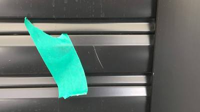 黒いアルミシャッターについた白い線傷