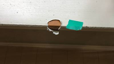 掃き出し窓の下枠（膳板）の角の表面シートが大きく剥がれ、下地が露出している状態