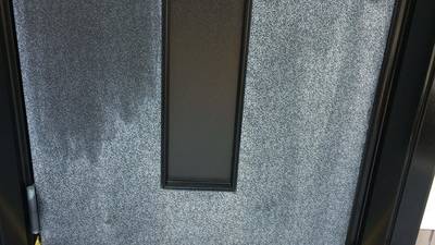 まだら模様に劣化した玄関ドアのアップ