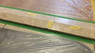 フローリングなどの周囲が汚れないよう、ビニールとテープで丁寧に養生された上がり框