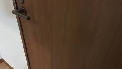 補修で傷が消え、元通りになった木目調ドア