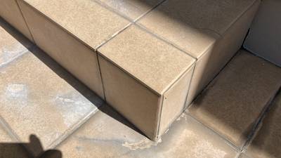 パテ埋めと塗装によって欠損部分が修復され、周囲と馴染んで綺麗になったベージュ色のタイル